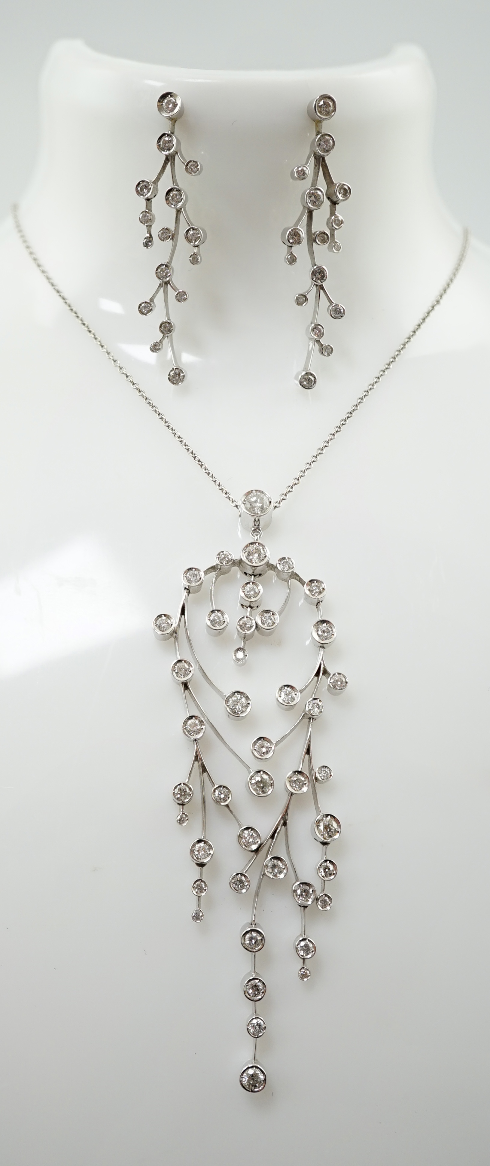 A modern 18ct white gold and diamond cluster set drop pendant on chain, together with a pair of matching drop earrings